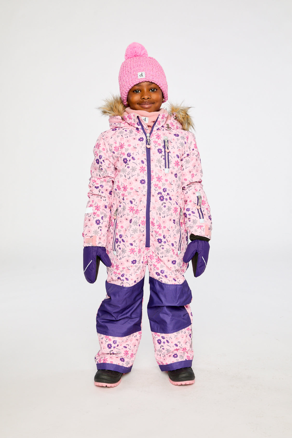 Child wearing the Deux par Deux kids PLAY one-piece snowsuit in Pink Mini Flower Print in a winter lookbook view