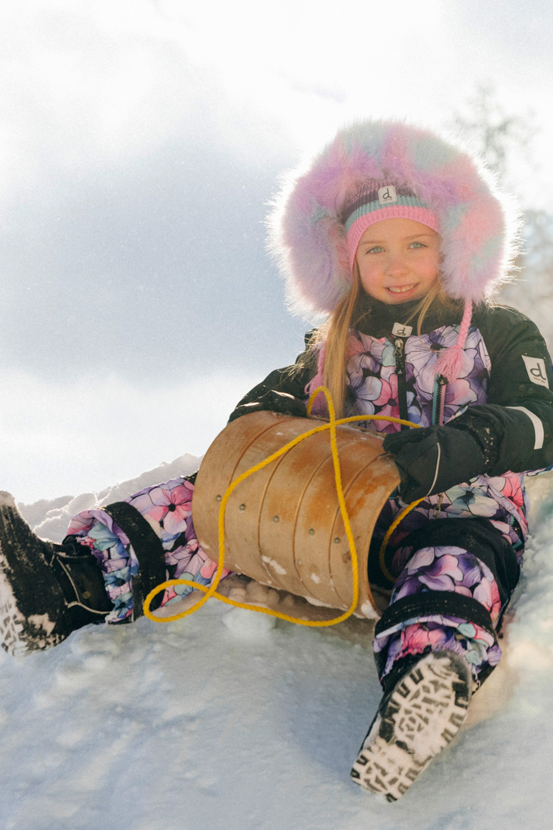 Deux par Deux girls purple floral one-piece snowsuit with articulated fit for active winter play.