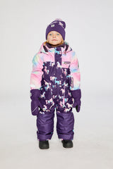 Child wearing the Deux par Deux kids PLAY one-piece snowsuit in Purple Unicorn Print in a winter lookbook view
