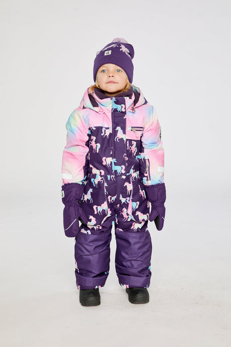 Child wearing the Deux par Deux kids PLAY one-piece snowsuit in Purple Unicorn Print in a winter lookbook view