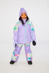 Front view of a child wearing the Deux par Deux lavender jacket and diamond-print snow pants with lavender knee panels