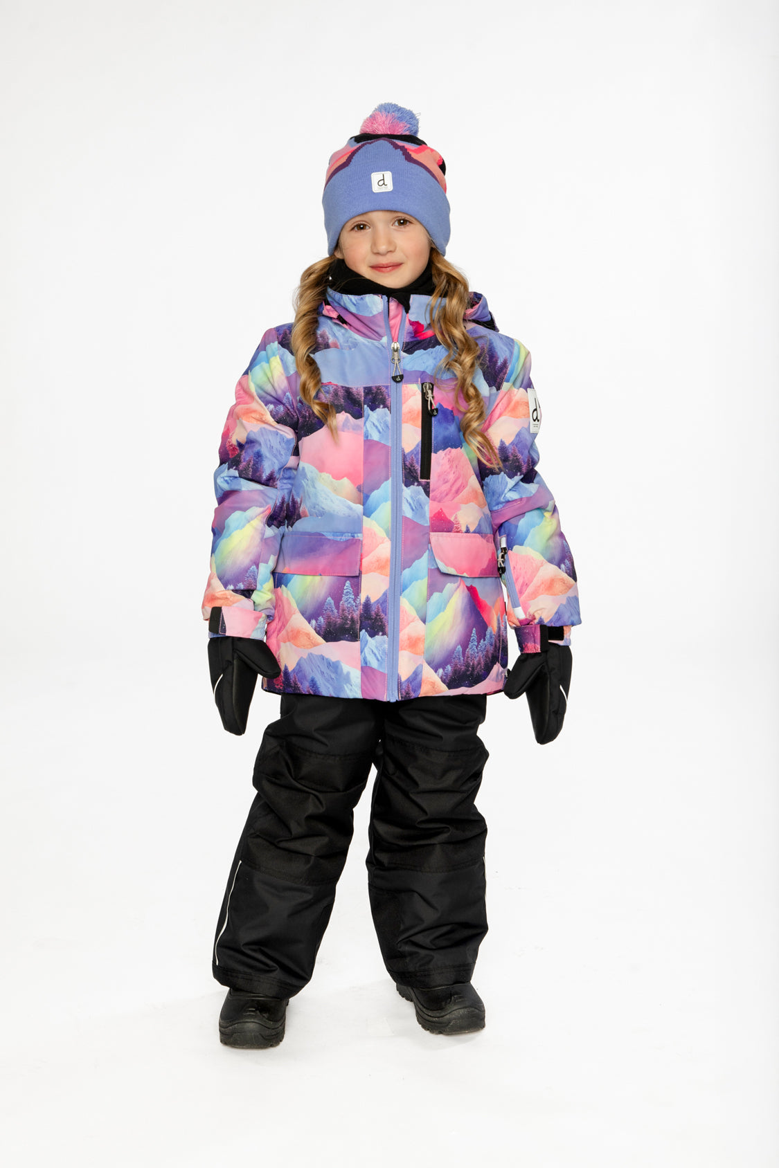 Front view of a child wearing the Deux par Deux pink mountain-print snowsuit with black snow pants