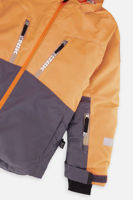 Close-up of the chest zip pockets and sleeve on the orange and grey TEKNIK jacket