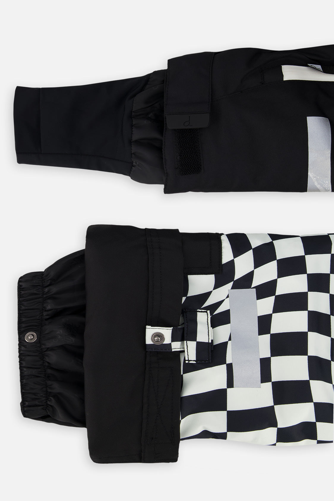 Close-up of the TEKNIK jacket cuff and the adjustable snow pant hem with snap tab