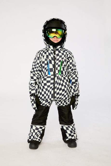 Child wearing the Deux par Deux TEKNIK two-piece snowsuit in White Checkered Print in a winter lookbook view