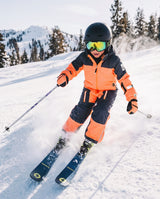 Deux par Deux boys' Teknik one-piece snowsuit in bright orange and blue – lifestyle photo