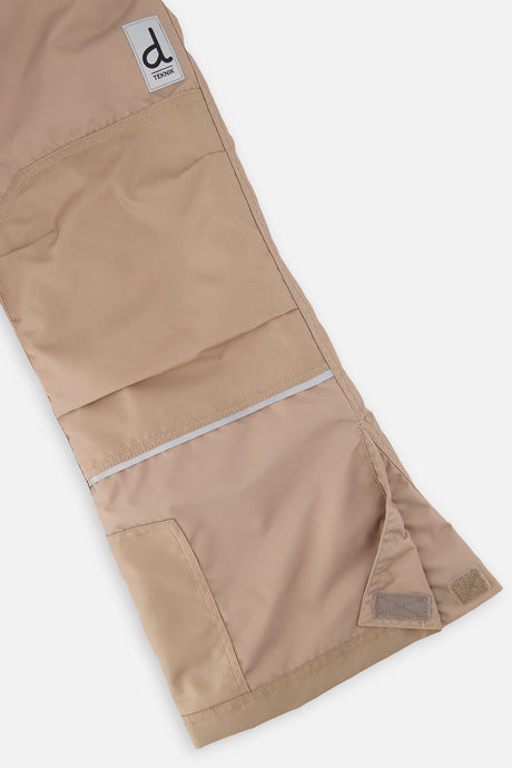 Close-up of the taupe snow pants leg with reinforced panels and inner snow gaiter