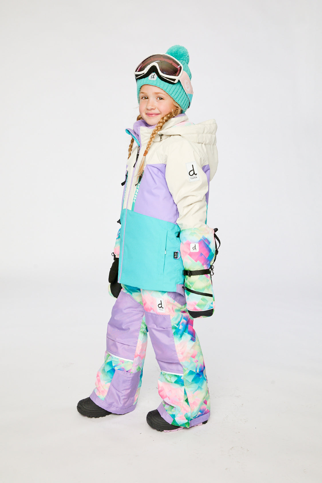 Deux par Deux TEKNIK two-piece snowsuit in Multicolored with A Diamond Pattern shown from an alternate modeled winter angle