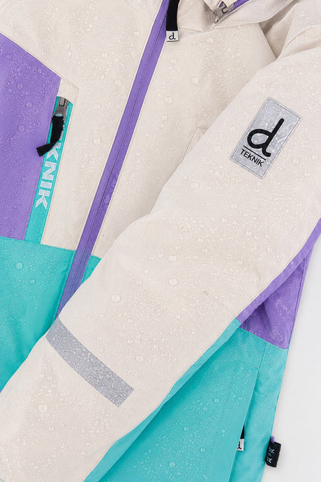 Water beading on the color-block TEKNIK jacket shell beside the logo patch