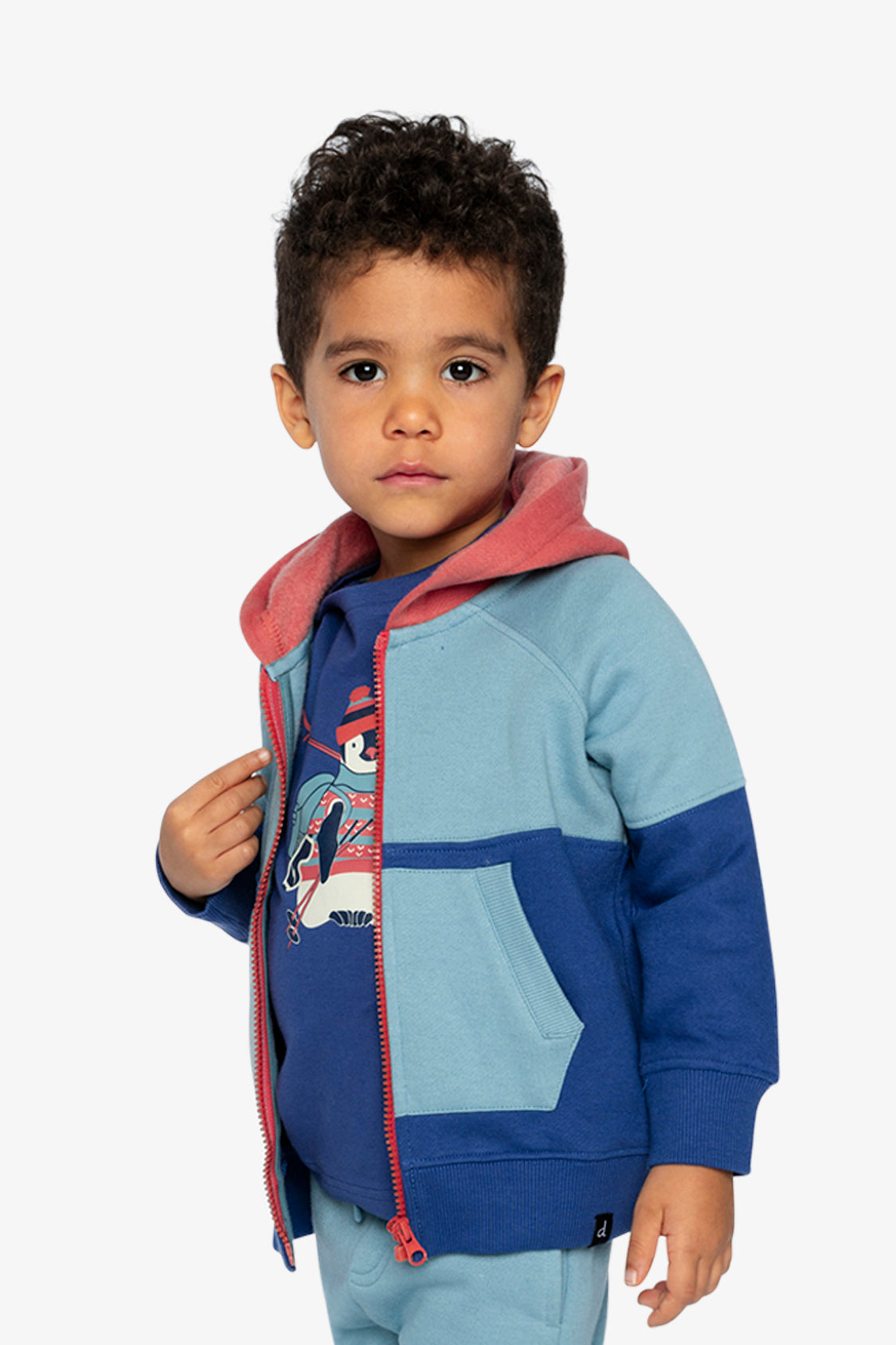 Boy in the Deux par Deux blue and turquoise fleece jacket with orange hood, second front pose