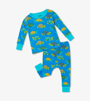 Front view of Hatley Baby Turtles pajama set in bright blue with colorful turtle print and turquoise cuffs.