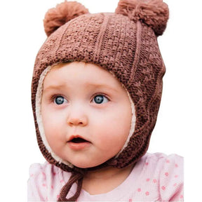 Baby wearing a brown bear cable-knit ear-flap hat, close-up