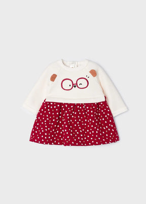 Front view of ivory and red baby fleece dress with glasses face motif