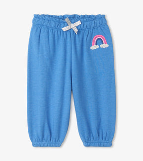 Hatley blue baby joggers with pink and white rainbow patch, bow and ruffled waist, front view