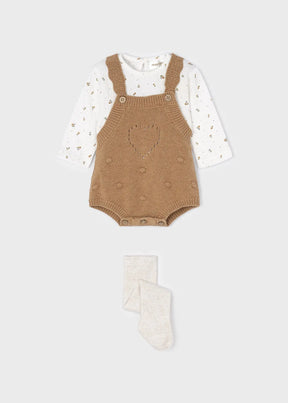 Front view of camel knit baby dungarees floral top and cream tights set