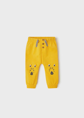Yellow baby boy joggers with zebra faces at the knees, front view