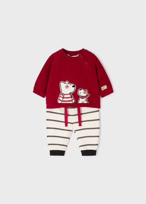 Front view of red dog sweatshirt and cream striped baby pants set