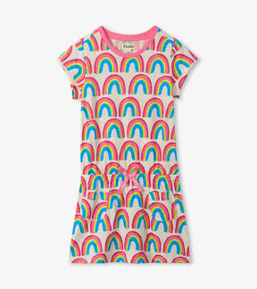 Hatley girls cream drop-waist dress with colorful rainbow print, pink trim and pockets, front view