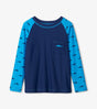 Front flat lay of Silhouette Sharks boys long sleeve rashguard with shark print sleeves and pocket