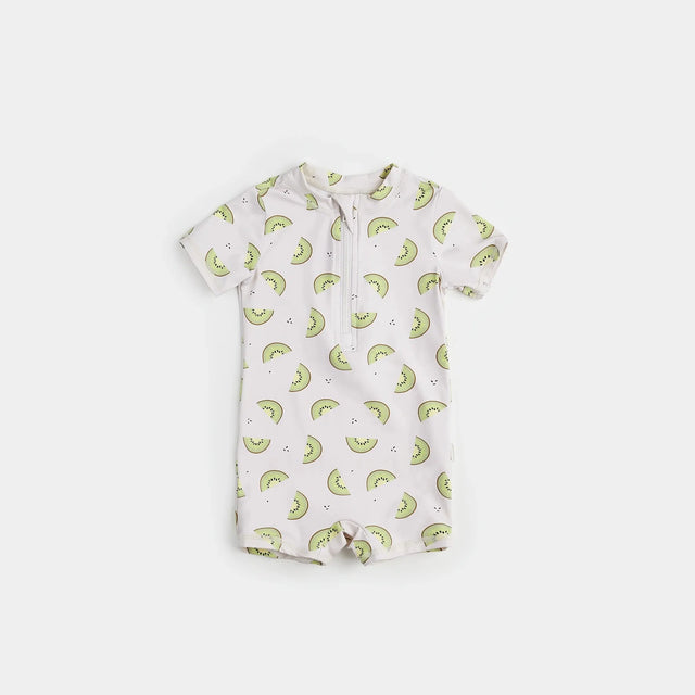 Kiwi print baby boy swim romper in crème and green on neutral background.