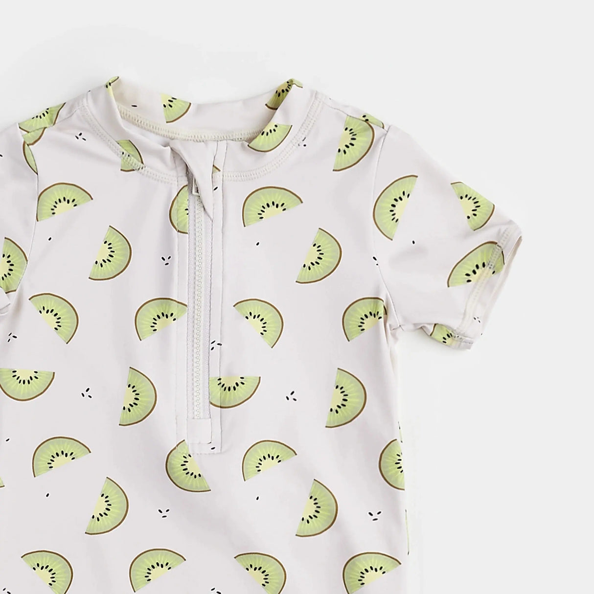 Front zip detail on kiwi print baby swim romper with long sleeves.