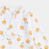 Close-up of lemon-print rashguard top showing front zipper and citrus pattern.
