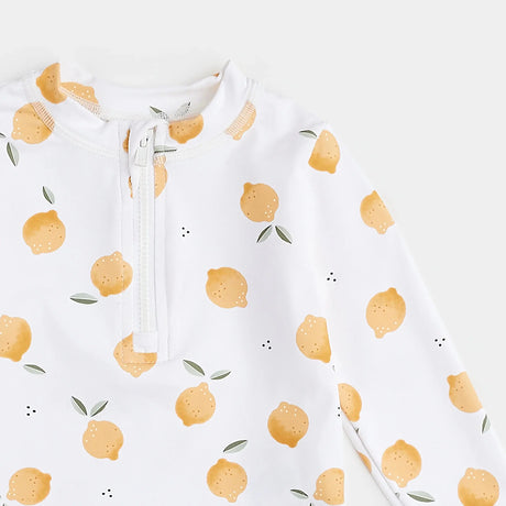 Close-up of lemon-print rashguard top showing front zipper and citrus pattern.