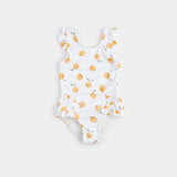 Off-white lemon-print one-piece swimsuit with frilly straps laid flat on neutral background.
