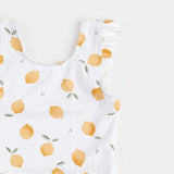 Close-up of lemon-print swimsuit neckline showing flutter straps and citrus pattern.