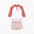 Red and white palm tree rashguard and striped swim shorts set for baby boy laid flat.
