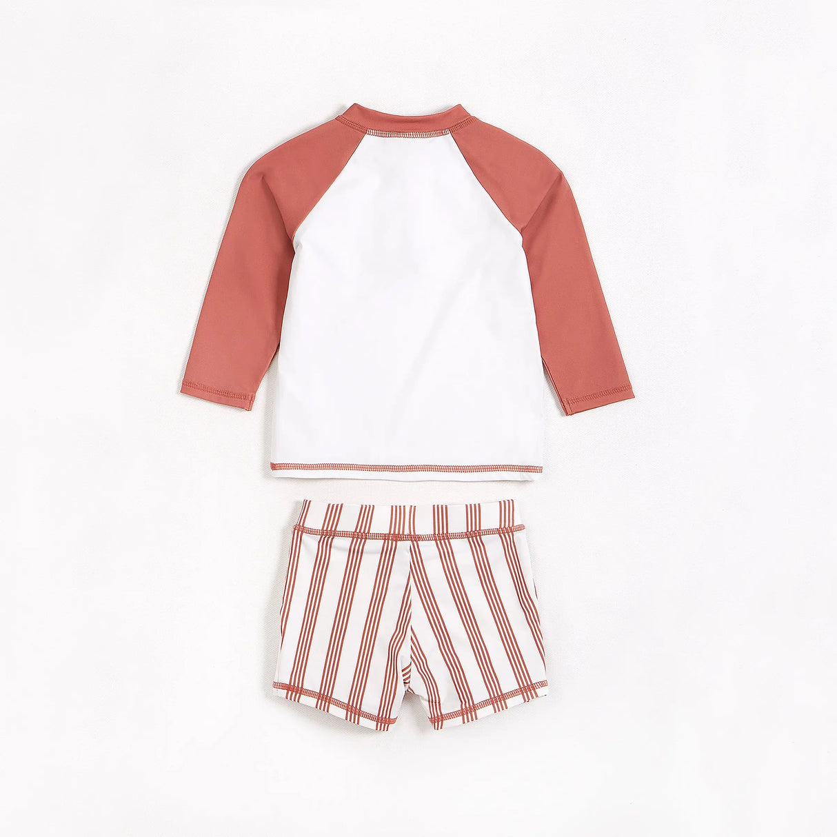 Palm tree raglan rashguard with matching striped swim shorts in red and white on neutral background.
