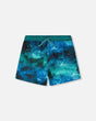 Front flat lay of Deux par Deux boy swim trunks in blue waves print