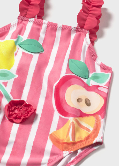 Closeup of Mayoral baby girl graphic swimsuit showing Pink stripes, ruffled strap, and colorful print.