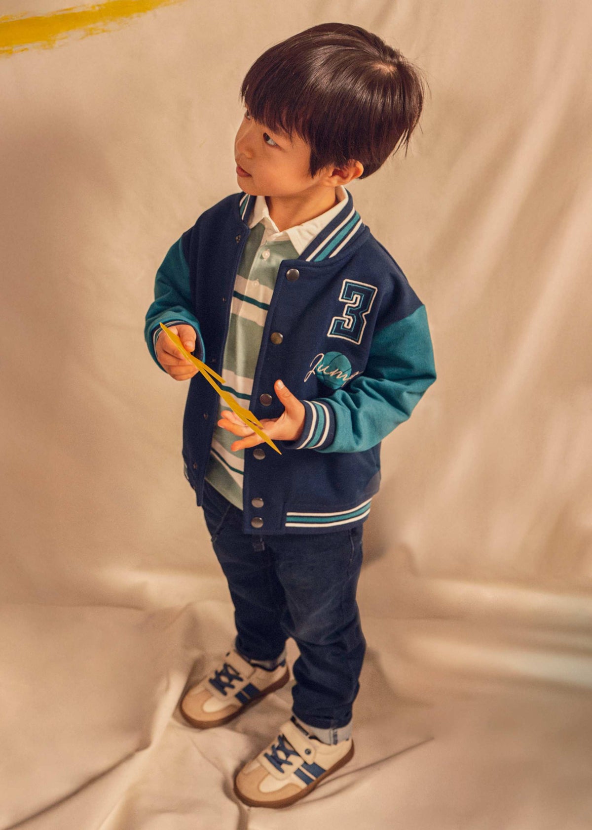 Boy wearing dark blue pull-on jeans with varsity jacket