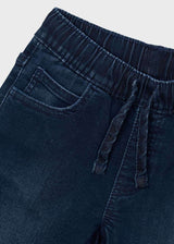 Close-up of elastic drawstring waist and front pocket on dark blue jeans