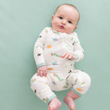 Baby wearing Kyte Baby Caterpillar zippered romper on soft green background