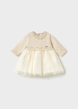 Front view of ivory Mayoral newborn girl dress with scalloped collar and gold-dot tulle skirt