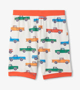 Matching boys pajama shorts in Cream with all-over trucks print and Orange waistband trim.