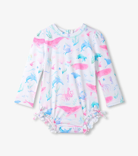 Hatley baby girl UPF50+ rashguard swimsuit with Painted Sealife print, long sleeves, and ruffled leg openings.